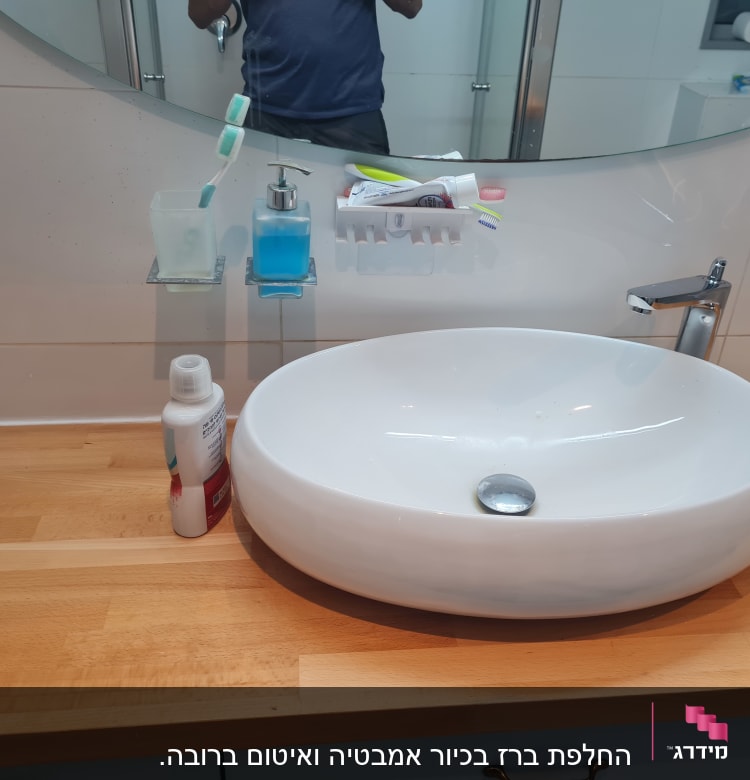 כיור עגול עם ברז כרום על משטח עץ